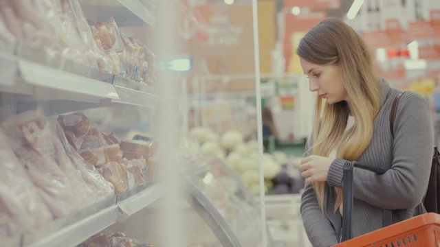 woman in supermarket choosing meat.