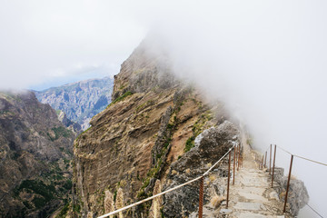Hiking trail in between clouds. Pico do Arieiro, at 1,818 m high, is Madeira Island's third highest...