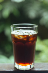 glass of ice coffee in garden background