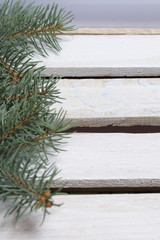 Blue spruce branches on a wooden box of boards, painted in white.