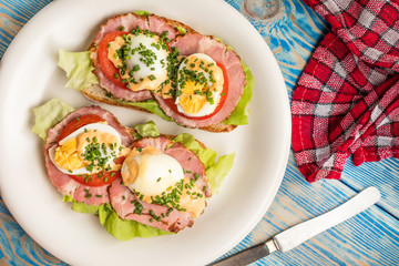 Sandwich with tomatoes, eggs and lettuce.