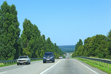 Asphalt road with dividing strip and landscapes on sides. Traveling concept