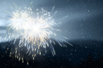 Fototapeta premium Evening sky with snowfall and magic bright multiple fireworks.