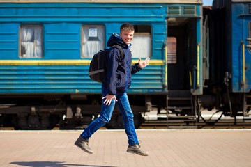 Young boy with big bags run at railway station. Travel by train