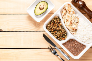 white rice chicken beans and manioc flour. Brazilian lunch box. top view