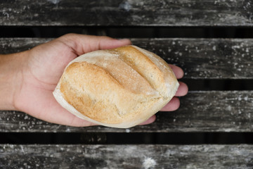 man with a bread roll in his hand