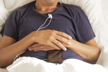 man in bed with his smartphone on top