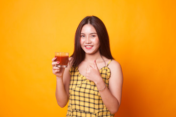 Young Asian woman thumbs up with tomato juice.