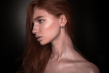 Fototapeta premium Beautiful serious redhead girl woman with healthy glow wet skin posing isolated over black wall background looking aside to empty copyspace.