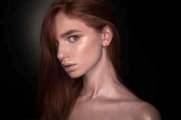 Fototapeta premium Serious redhead girl woman with healthy glow wet skin posing isolated over black wall background looking at camera.