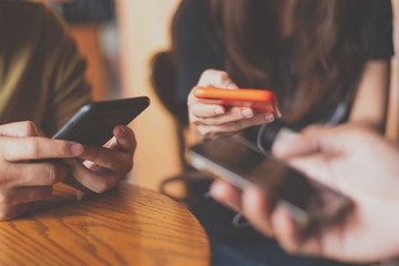 Closeup of hands social networking with mobile cellphones,Group of friends having fun together with...