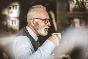 Elderly man enjoying in coffee.