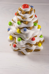 Gingerbread Christmas tree decorated with glaze on white wooden table