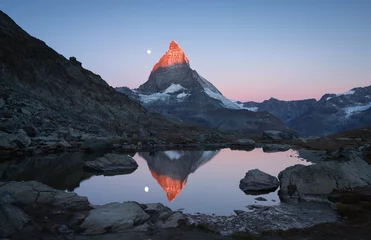 Papier Peint photo Cervin The famous Riffelsee and the Matterhorn, with the moon and the first sunlight shining on the mountaintop.