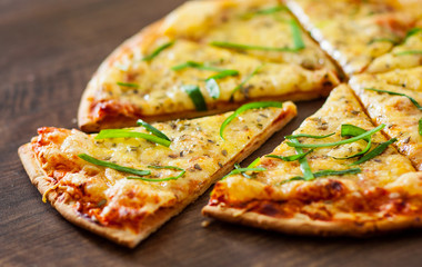 sliced Pizza Margherita or Margarita with Mozzarella cheese. Italian pizza on wooden background
