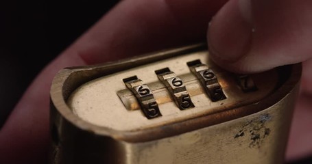 Loop of Person spins combination lock, close up. Loop 1 of 2.