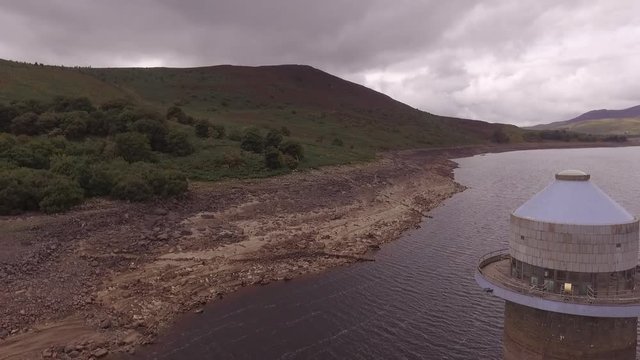 Aerial shot of Llyn Celyn reservoir flying slowly away from the intake tower during the drought in 2018.