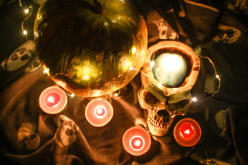 Fototapeta na wymiar Helloween skull with blue brains and pumpkin in the dark with a garland.