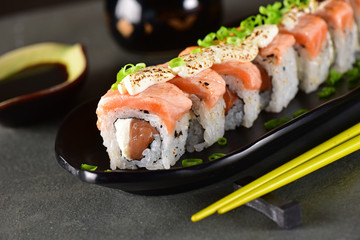 Salmon sushi roll aligned on plate