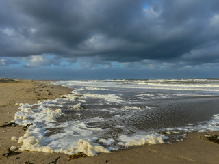 Kijkduin beach, The Hague, the Netherlands - October 3 2018: foam washing ashore during north sea storm on dutch coast