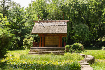 Shelter, wooden gazebo in the park and green grass