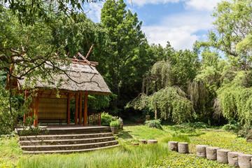 Shelter, wooden gazebo in the park and green grass