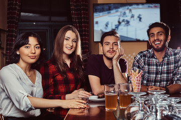 Young multiracial friends resting in the pub.