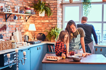 Family together cooking breakfast in loft style kitchen.