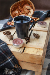 Autumn atmospheric composition of the home layout.Box from the vines, bumps, candles, cup of tea, autumn decor, wooden board and textiles.