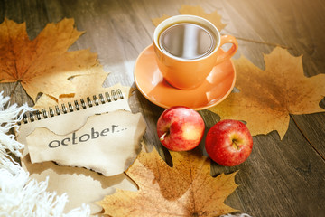 Autumn background with yellow maple leaves, red apples and black coffee. Mockup for seasonal offers and holiday post card, top view. Gold October. Selective focus.
