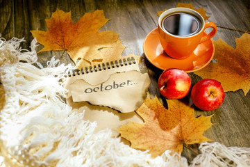 Autumn background with yellow maple leaves, red apples and black coffee. Mockup for seasonal offers and holiday post card, top view. Gold October. Selective focus.