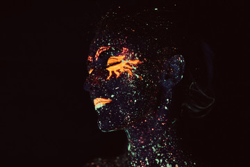 Portrait of a girl painted in fluorescent powder. Halloween concept.