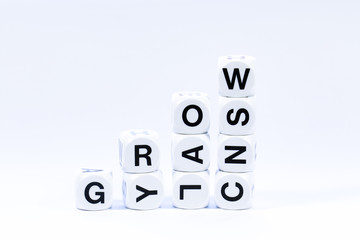 Lettered dice spelling out the word grow on a white background