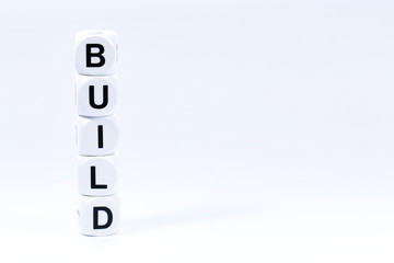 Lettered dice spelling out the word build on a white background