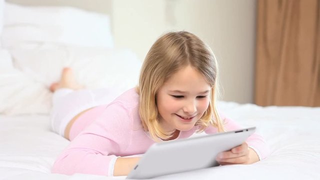 Loop of Blonde girl touching a tablet computer