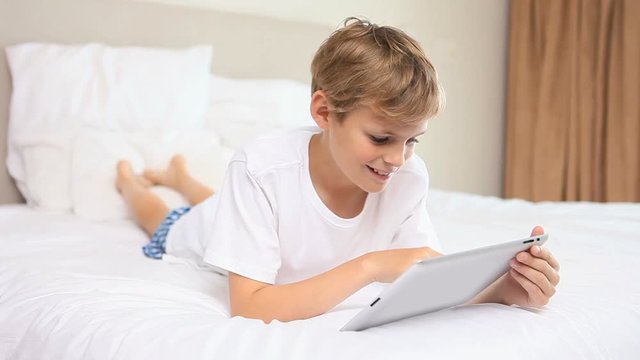 Loop of Smiling boy using a tablet pc