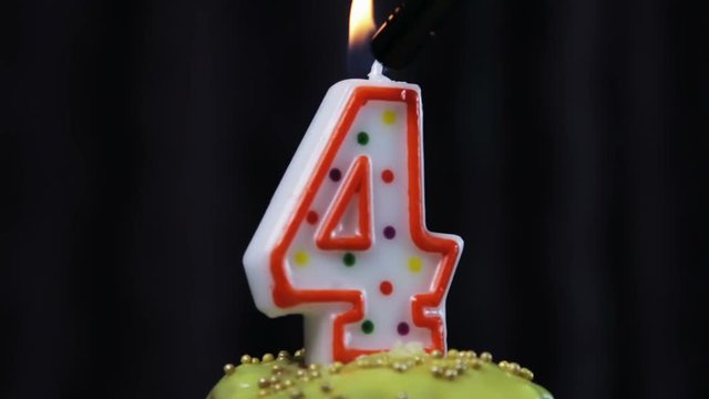 cupcake with a burning candle with the number 4. Congratulations on your first birthday. video rotation