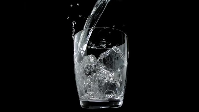 Loop of Pouring water into glass with ice cubes shooting with high speed camera, phantom flex.