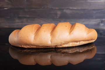 Bread on a black mirror background, , fresh pastry concept.