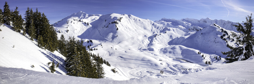 Panoramic view of Portes du Soleil, Alpes. Winter landscape in sunny day with low clouds.