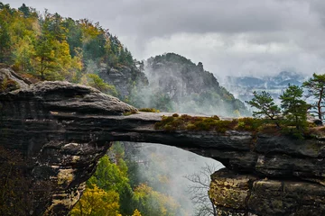 Foto op Canvas Mistige mistige landschap van de Pravcicka-poort (Pravcicka brana) de grootste natuurlijke zandstenen boog in Europa in Tsjechisch Zwitserland (Boheems Zwitserland of Ceske Svycarsko) Nationaal Park © Vladimir V