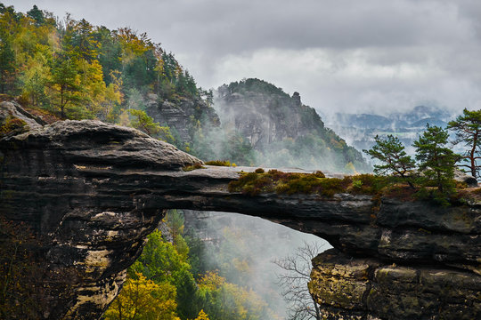 Fototapeta Misty foggy landscape of the Pravcicka gate (Pravcicka brana) the largest natural sandstone arch in Europe in Czech Switzerland (Bohemian Switzerland or Ceske Svycarsko) National Park