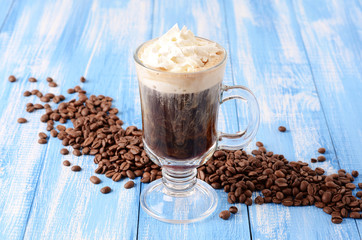 Irish coffee on a blue wooden background with coffee beans