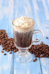 Irish coffee on a blue wooden background with coffee beans