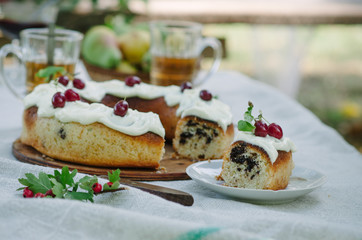 Bundt cake with cinnamon covered with white glaze on rustic background with autumn decorations
