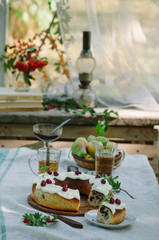Bundt cake with cinnamon covered with white glaze on rustic background with autumn decorations