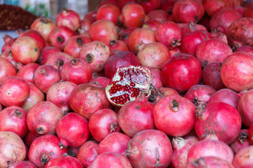 KASHGAR, XINJIANG / CHINA - October 1, 2017: Close up of pomegranates - on display for sale at a market in Kashgar. Pomegranates originate in the region extending from Iran to northern India.