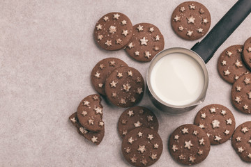 Chocolate cookies with jar of hot milk on the gray slate background.