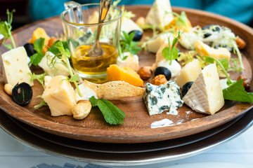various kinds of cheeses and honey on plate