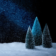 Verschneiter Weihnachtsbaum vor tiefblauem Hinterdrund mit Schnee
